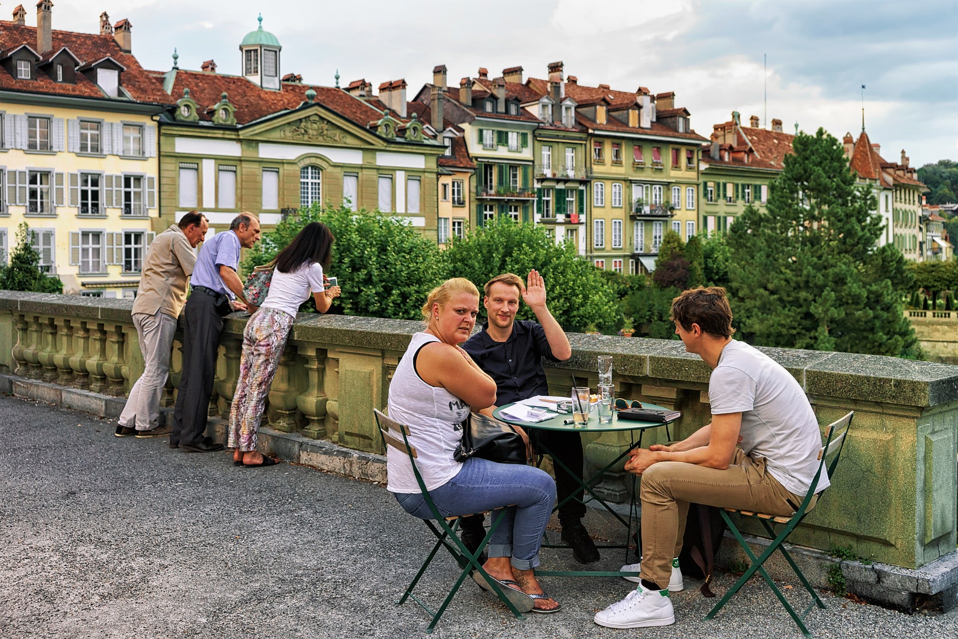 Priatelia pri stolíku kaviarne na terase Münsterplattform v starom meste v Berne
